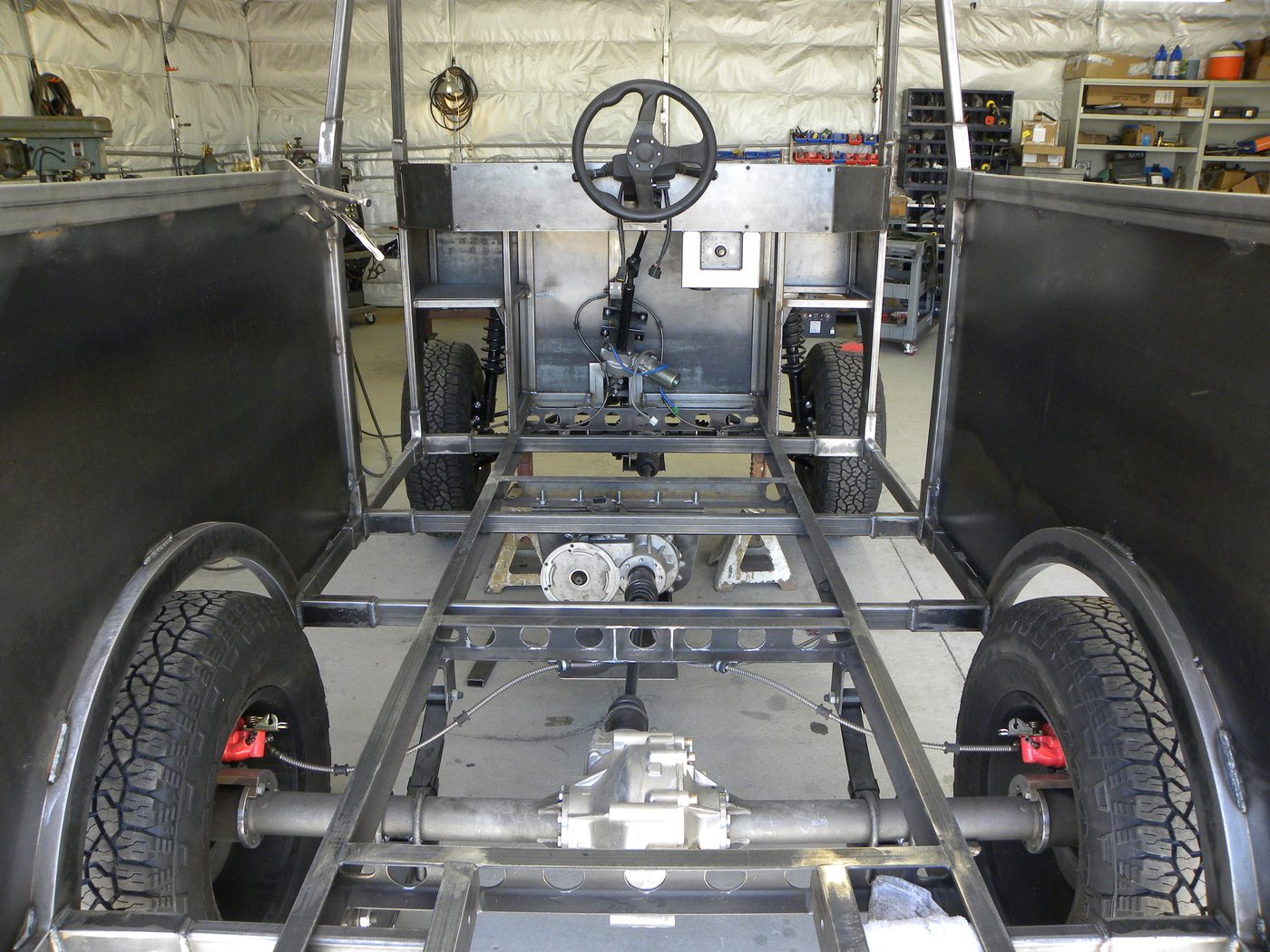 An Enabler frame in the shop, showing the welded steel chassis, rear axle and gearbox