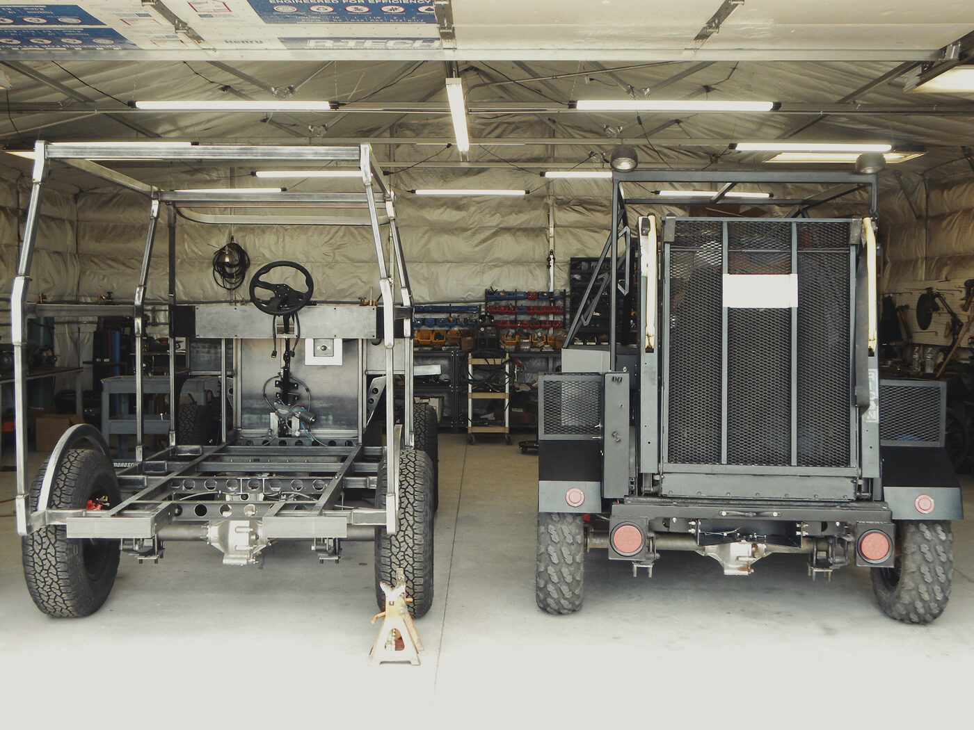 The Enabler 2.0 and the unfinished 2.1 chassis side by side in the shop, rear view