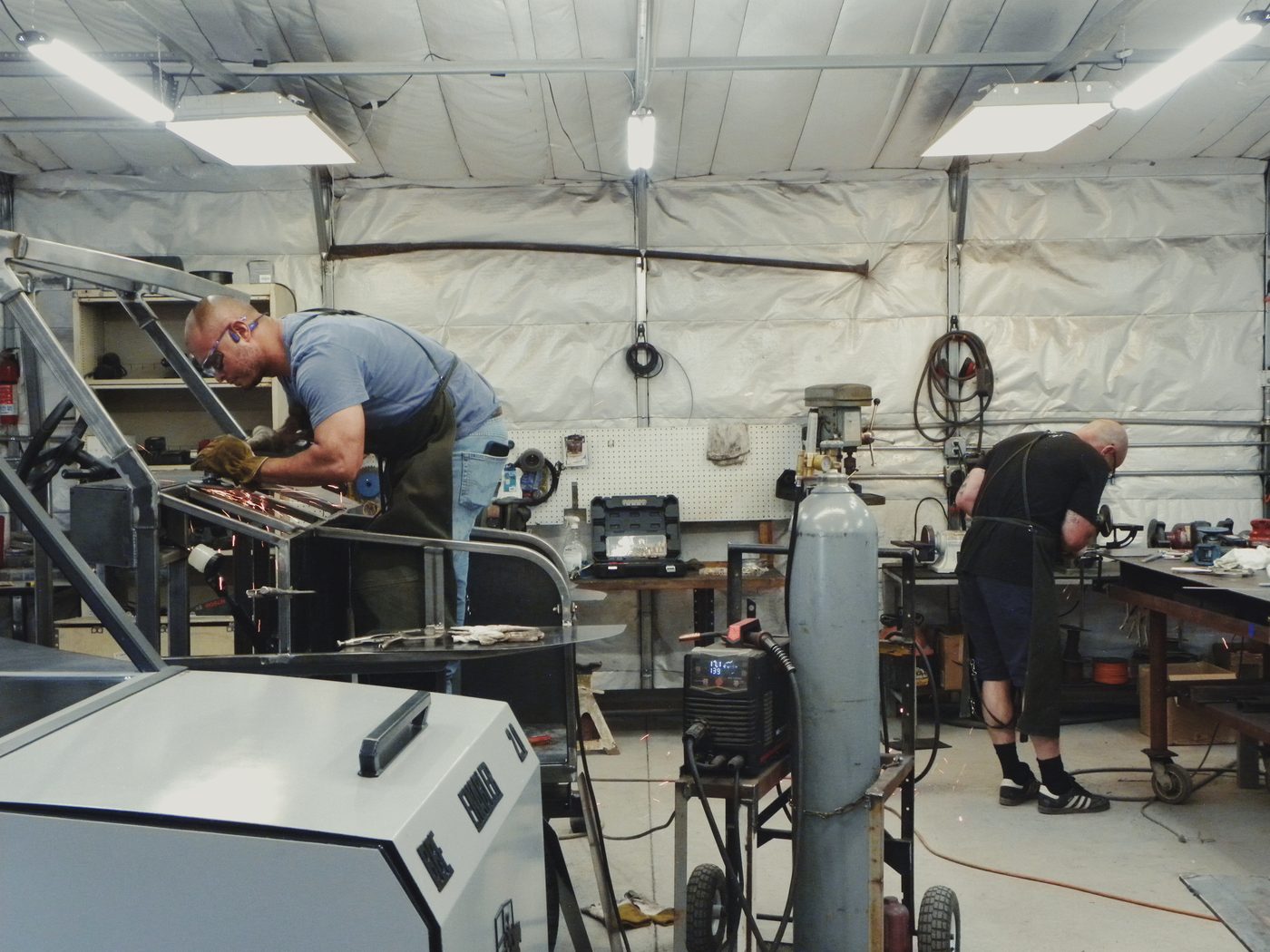 Two fabricators working at benches in the Albuquerque shop