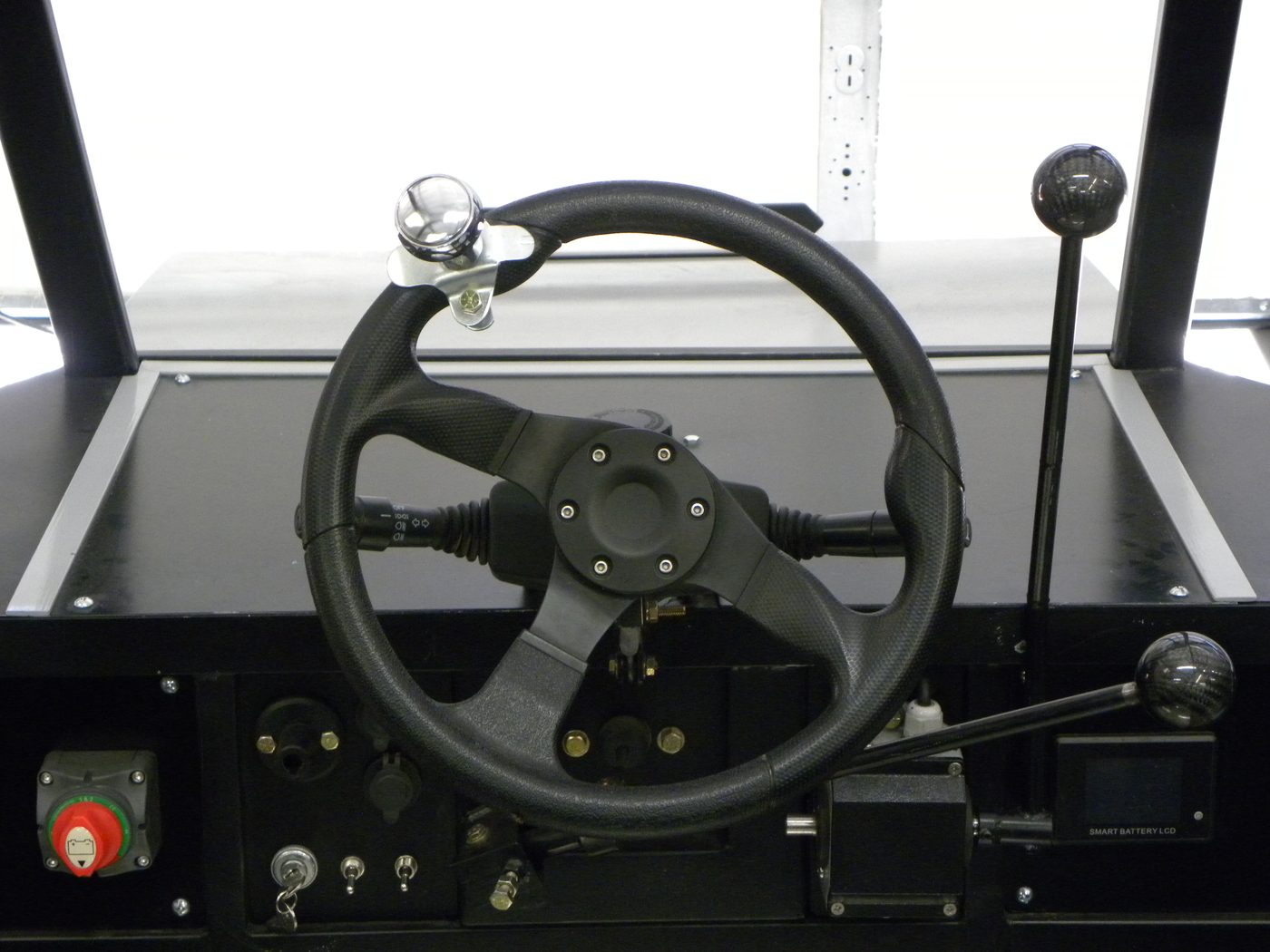 Front view from the driver's seat of the Enabler's steering wheel, hand-control joystick and dash controls